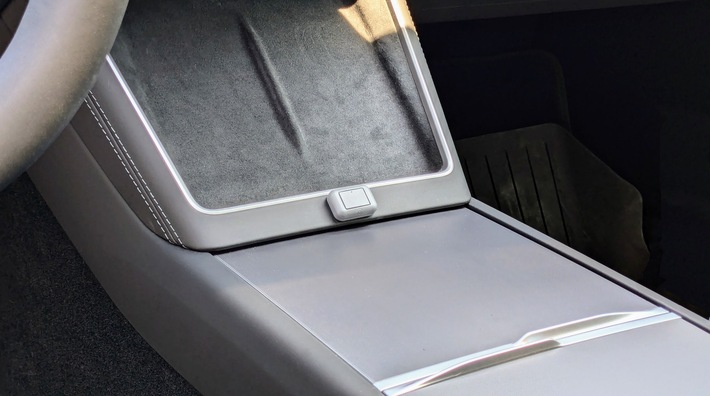 Button near Tesla charging port area